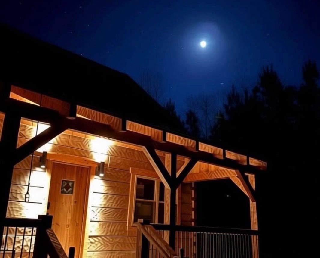 Cabin entrance glowing at night under the moon